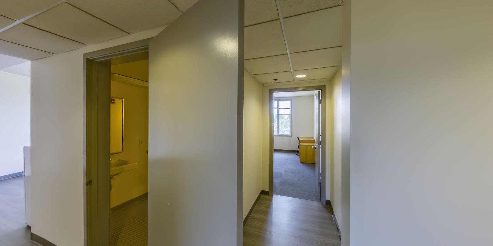 This side of the first hallway leads to a single bedroom and a bathroom.