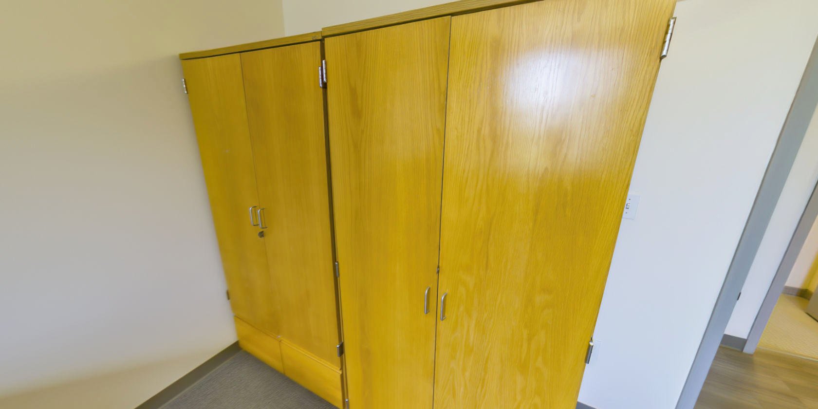 This side of the bedroom has two sets of closet storage with small latches for padlocks near the entrance.