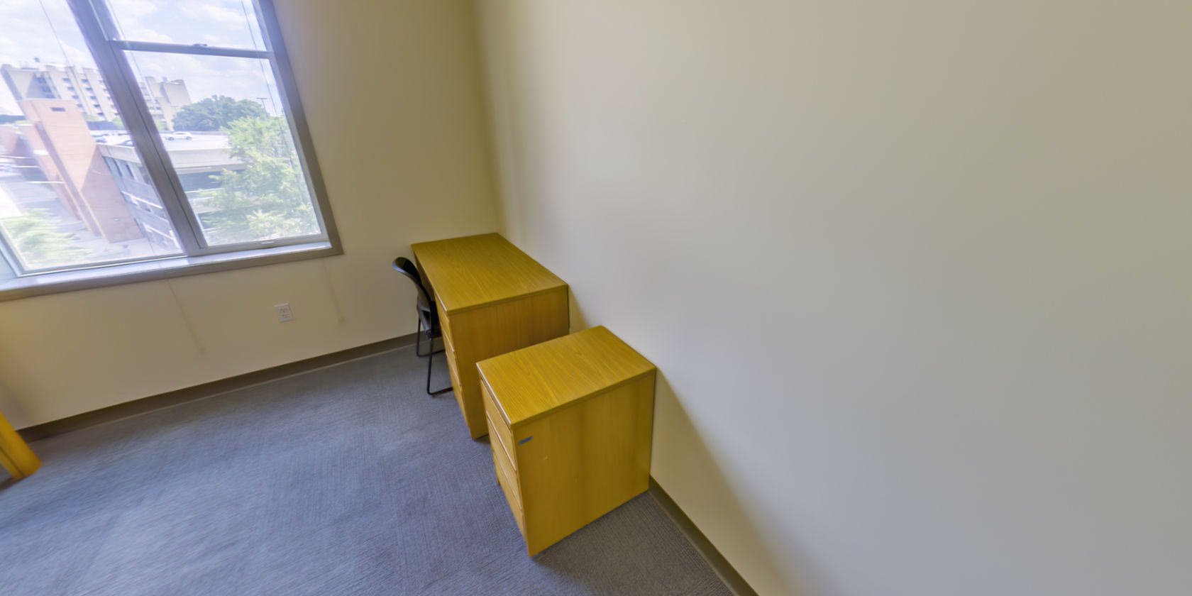 This side of the bedroom has a desk with drawers and more bedside storage.