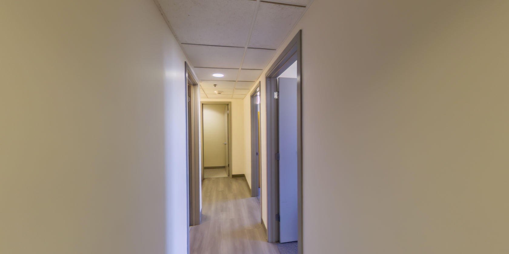 This second hallway, with laminate flooring, connects to two more double bedrooms and an additional bathroom.