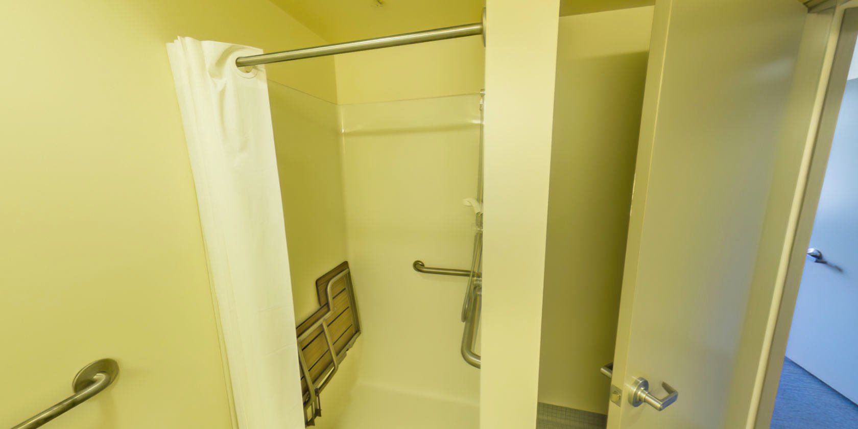 This side of the bathroom has an accessible shower with a fold-down bench.