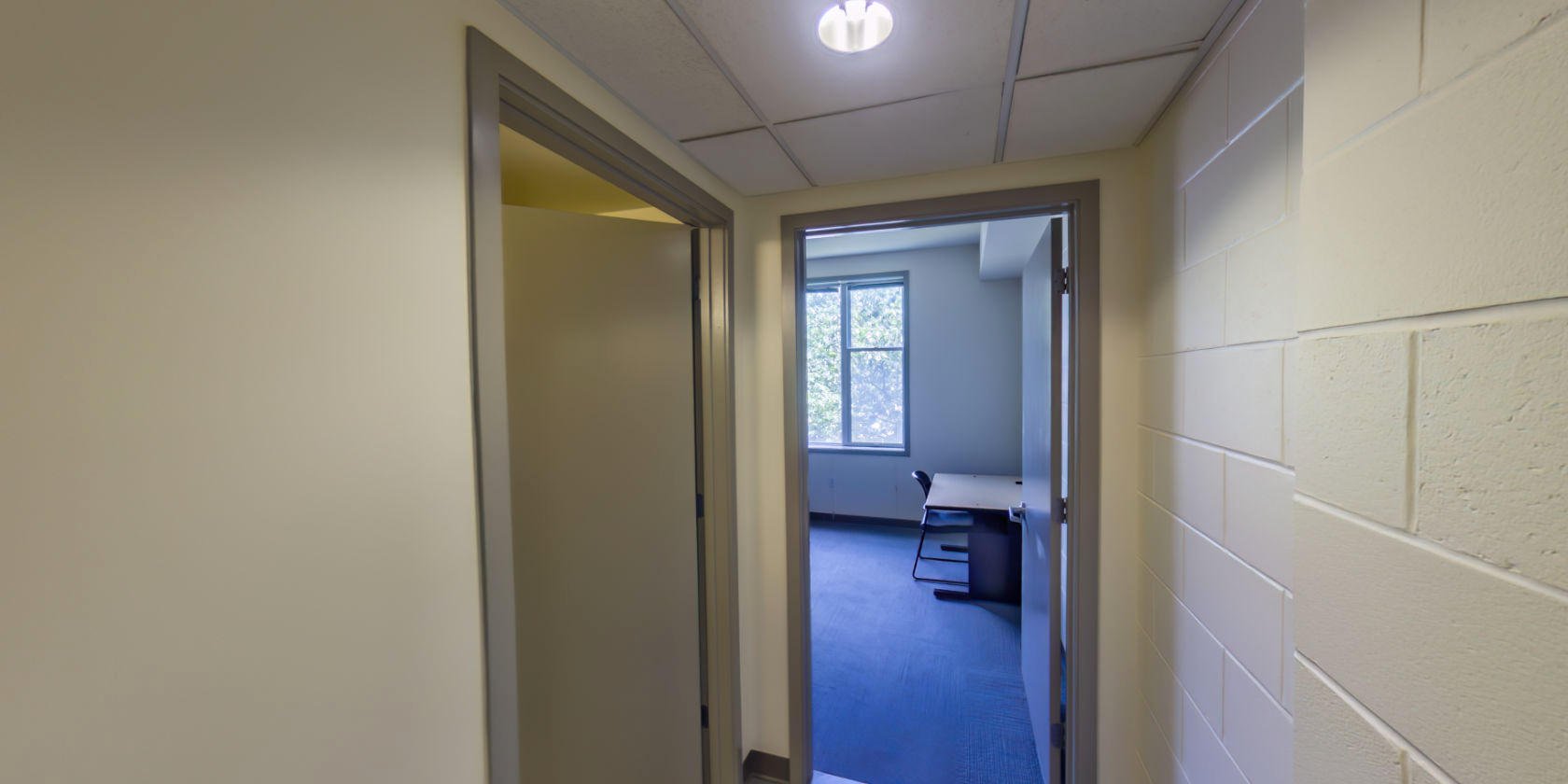 This side of the hallway leads to a second bathroom and a third bedroom.