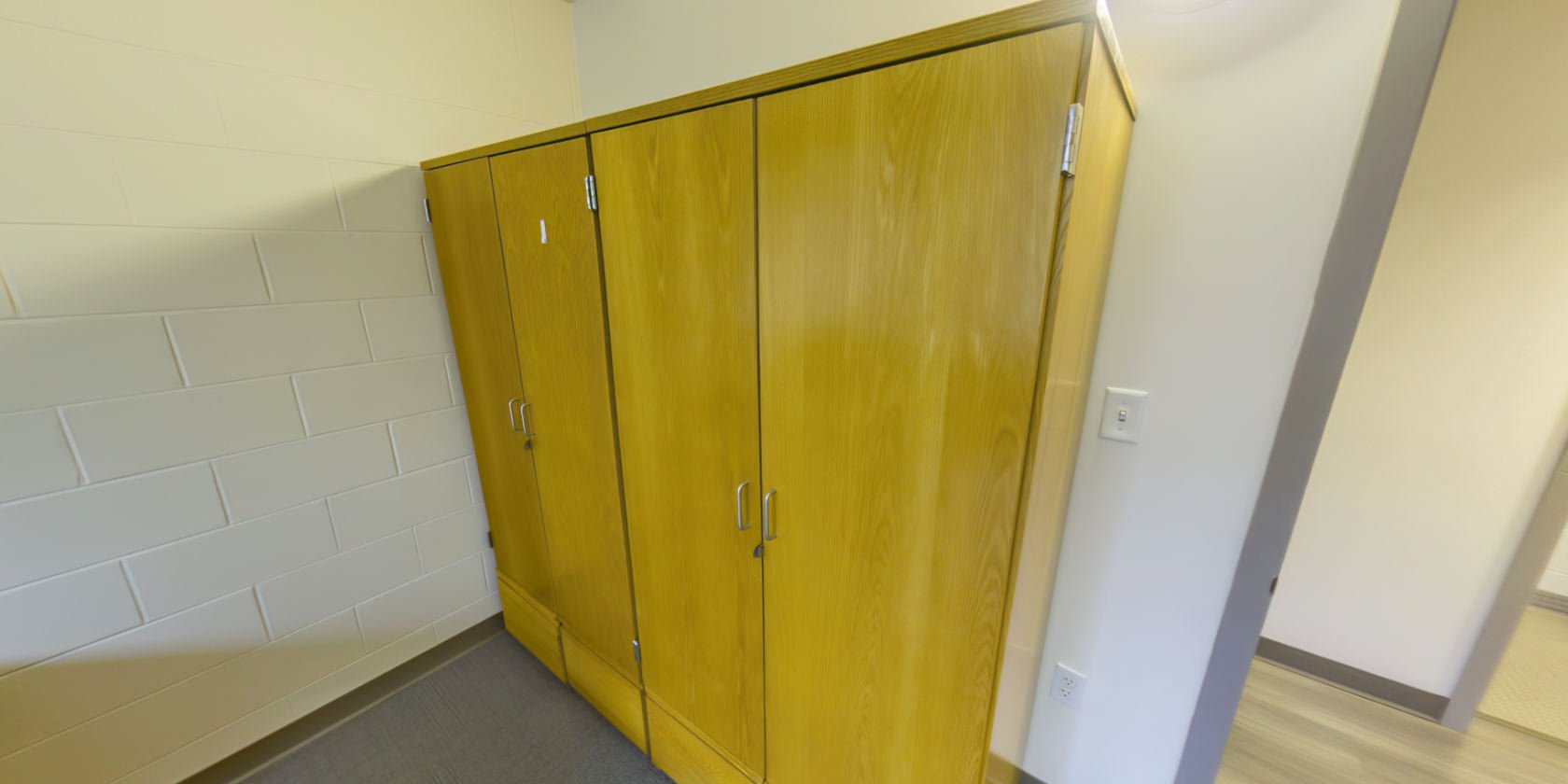 This side of the bedroom has two sets of closet storage with small latches for padlocks near the entrance.