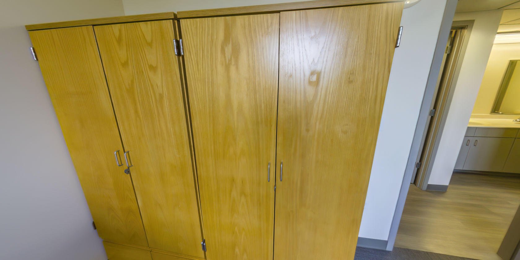 This side of the bedroom has two sets of closet storage with small latches for padlocks near the entrance.