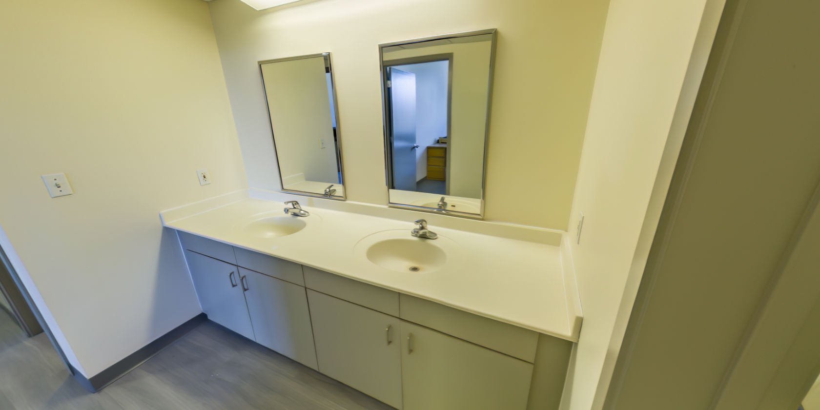 This side of the hallway has access to a second area with double vanities.
